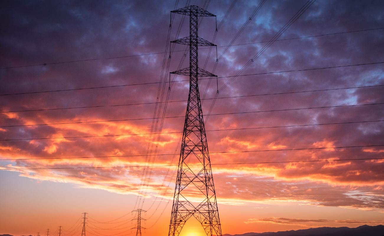 torre de transmisión de ISA en Chile. De fondo hay un cielo con destellos naranjas